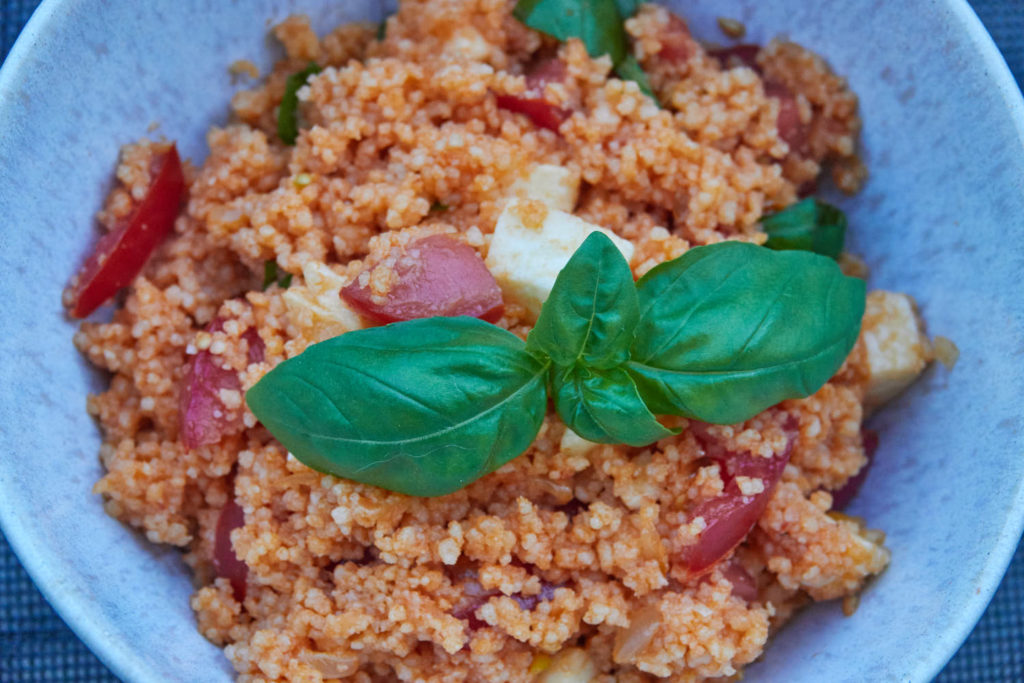 Couscous Nahaufnahme mit Tomate, Mozzarella und Basilikumblättern